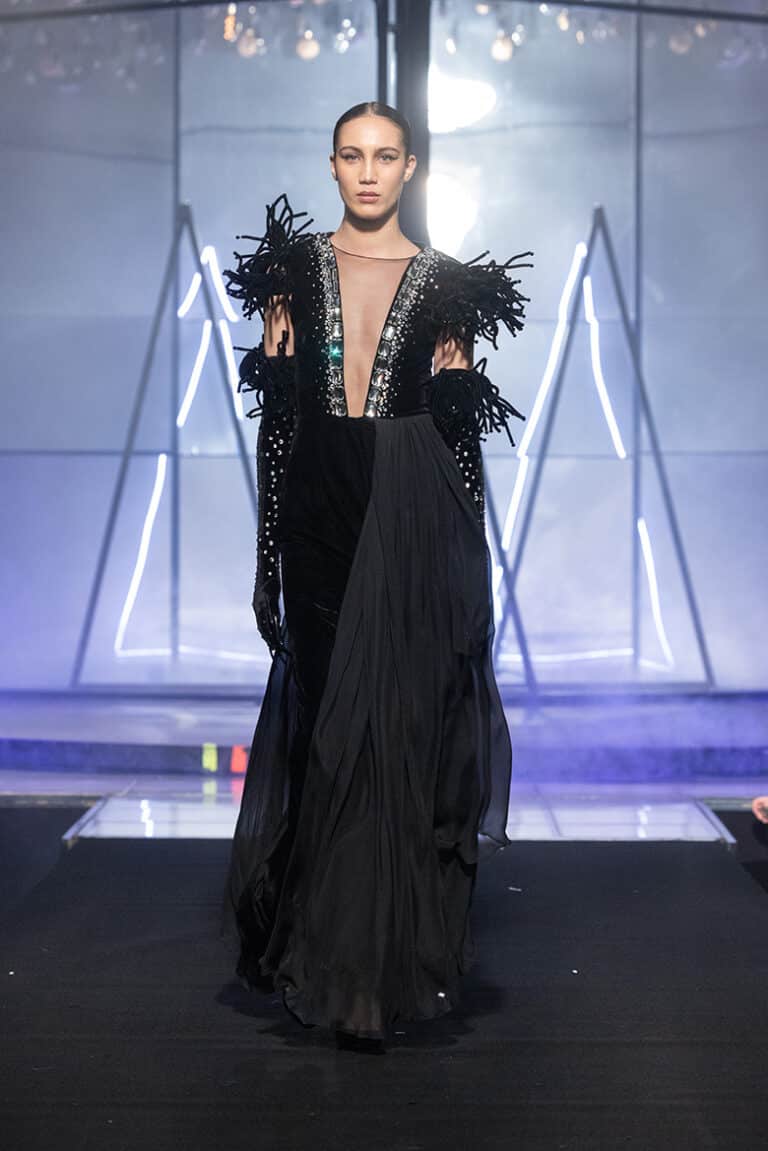 A model walks the On Aura Tout Vu couture runway wearing a sparkling ebroidered velvet and silk chiffon dress and gloves