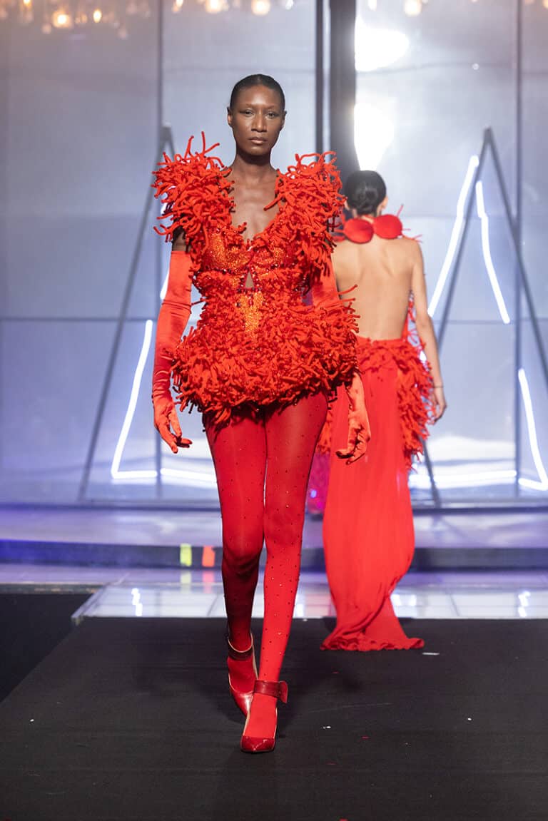 model walk on aura tout vu show wearing red embrodered bodysuit and red gloves