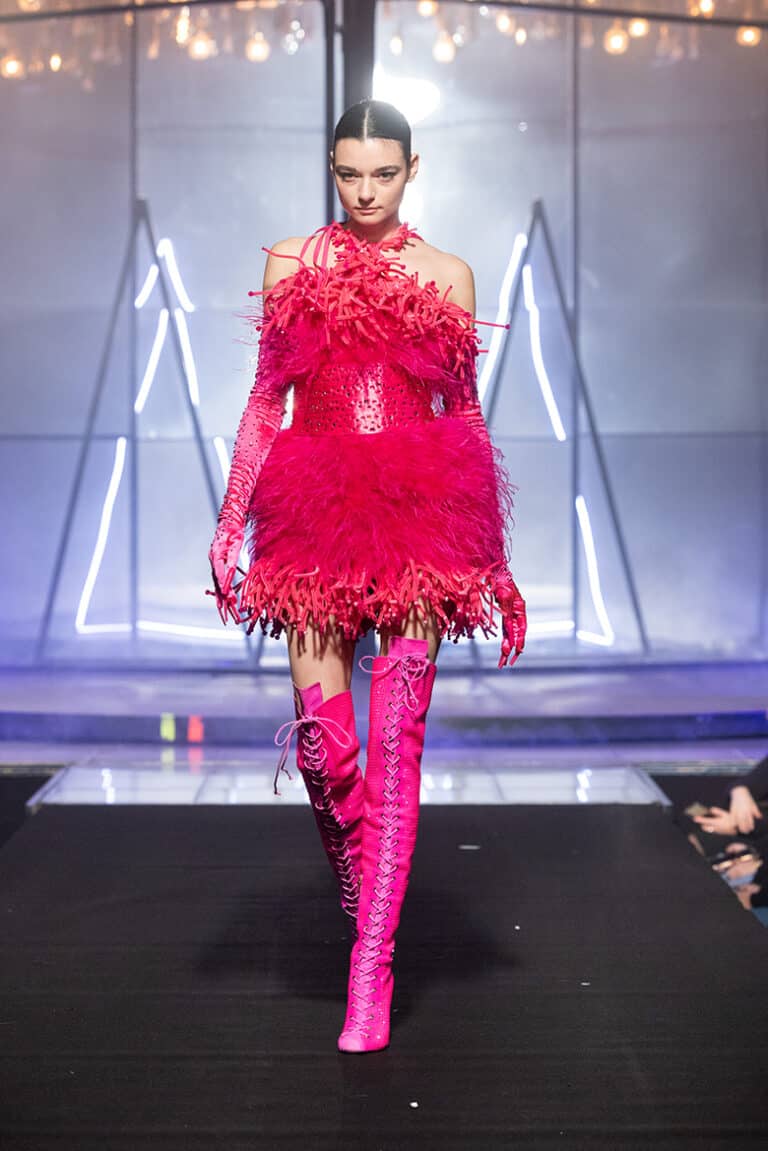 a model wearing pink feathers dress and cristal boots