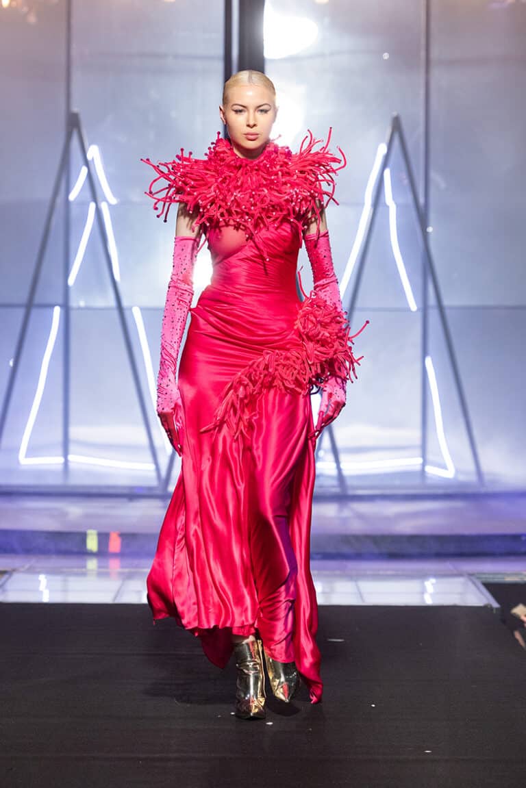 a model wearing pink fringes and spikes silk satin dress