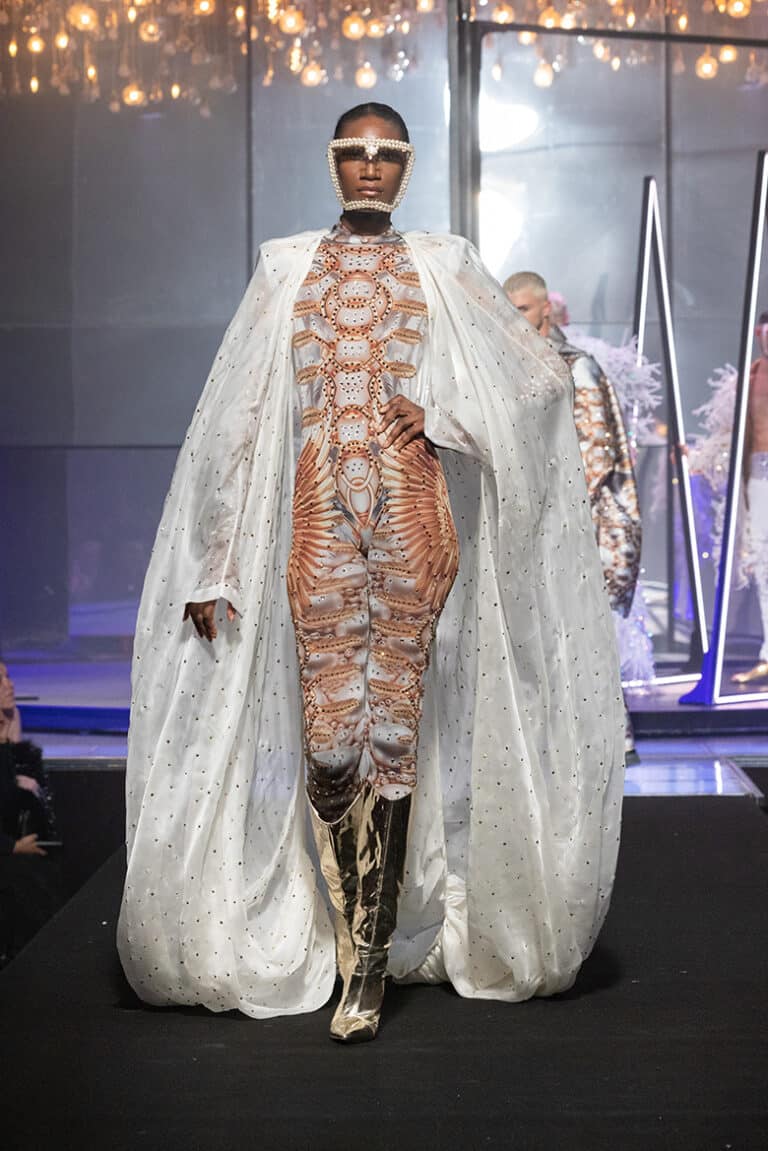 A model walk on aura tout vu show wearing custom print pearls bodysuit and white silk cape